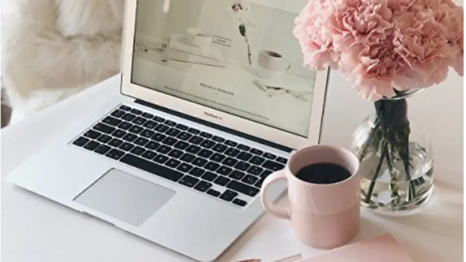 Laptop with coffee mug and flower