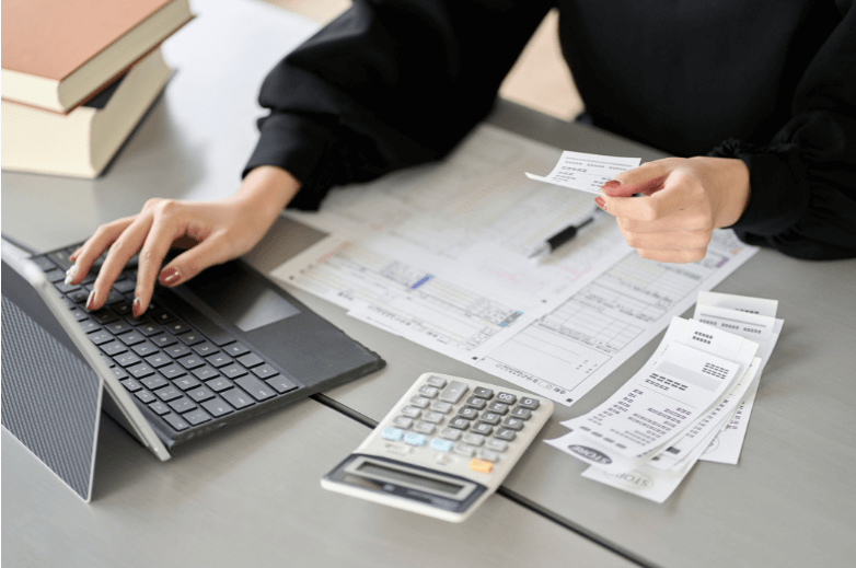 Desk with Papers, Calculator, and Laptop